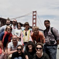 Rezidenti pobytu a organizačný štáb projektu pri moste Golden Gate v San Franciscu. Horný rad zľava: Tomáš Umrian, Erik Šille, Lucia Tallová, Lenka Sršňová, Fero Király, Matej Lacko. Spodný rad zľava: Zuzana Godalová, Július Krištof, Zuzana Žabková, Veronika Šrámatyová a Lucia Királyová.
